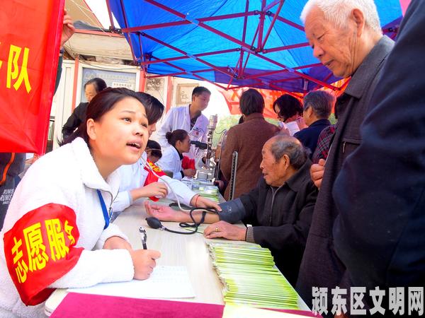 志愿者在详细的给老人讲解保健知识